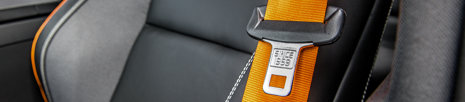 image of driver's seat in a car with an orange seat belt